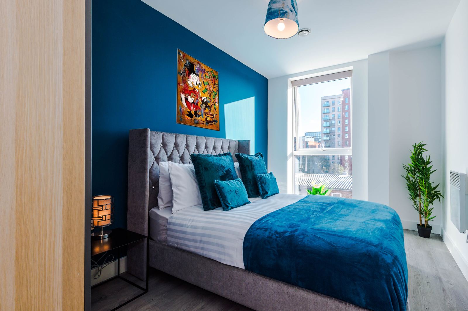 Bridgewater apartment bedroom with teal accent wall and pop-art canvas