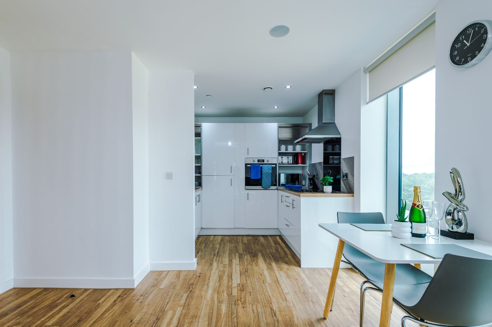 Bright open-plan kitchen and dining area with wood flooring and city views