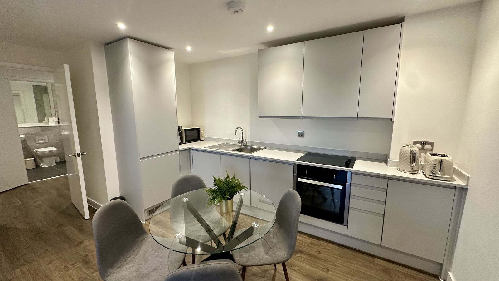 Waterhouse contemporary kitchen with grey cabinetry, dining table and ensuite bathroom